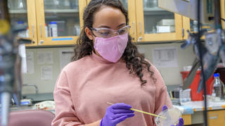 lab student holding a petri dish