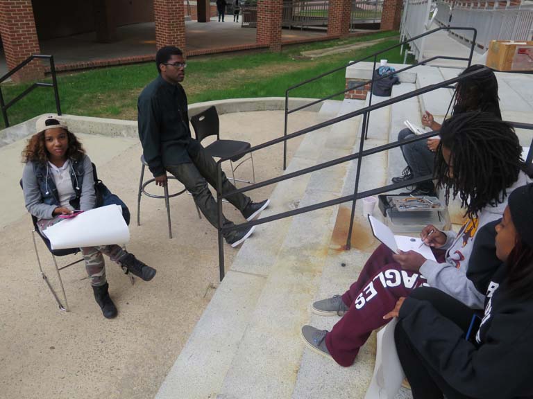 A group of arts students sitting outside the arts building