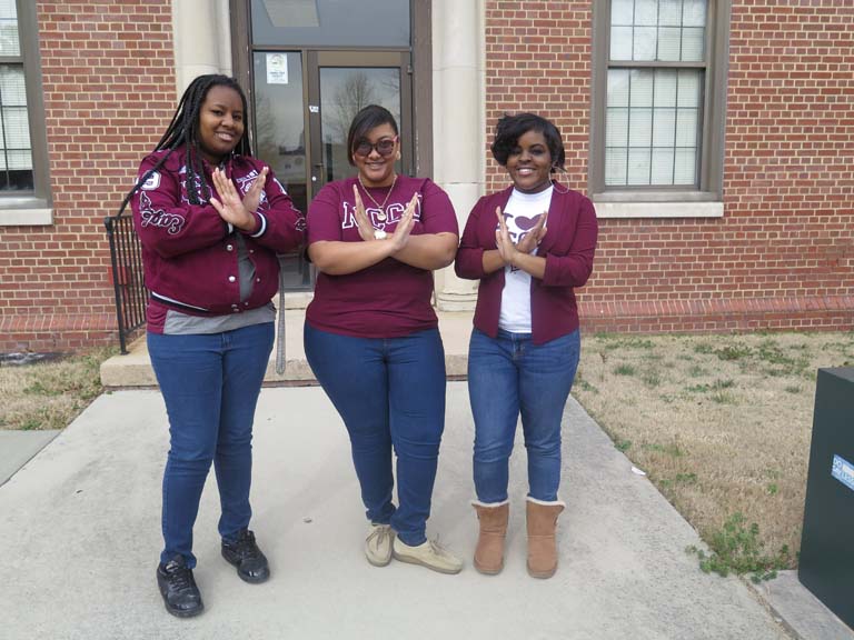 3 students posing by the Fine Arts Building