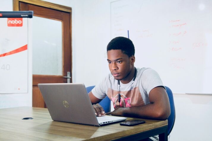 A student in a study room looking at a laptop screen