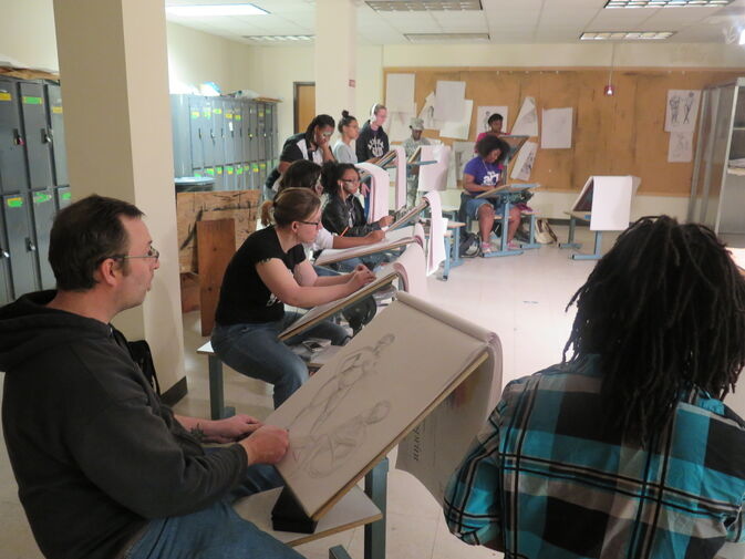 A group of students drawing on easels 