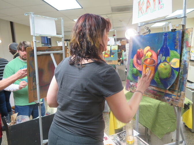 A student working on a painted art piece