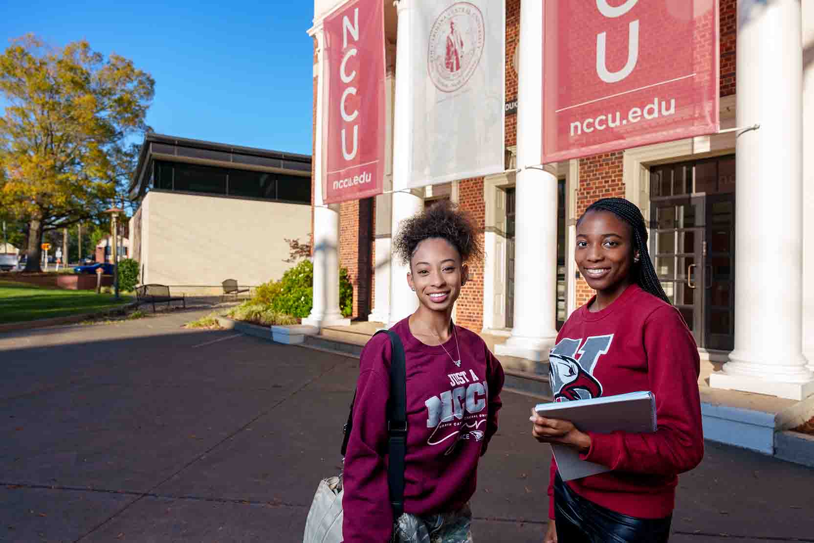 Two students posing in front of the fine arts building