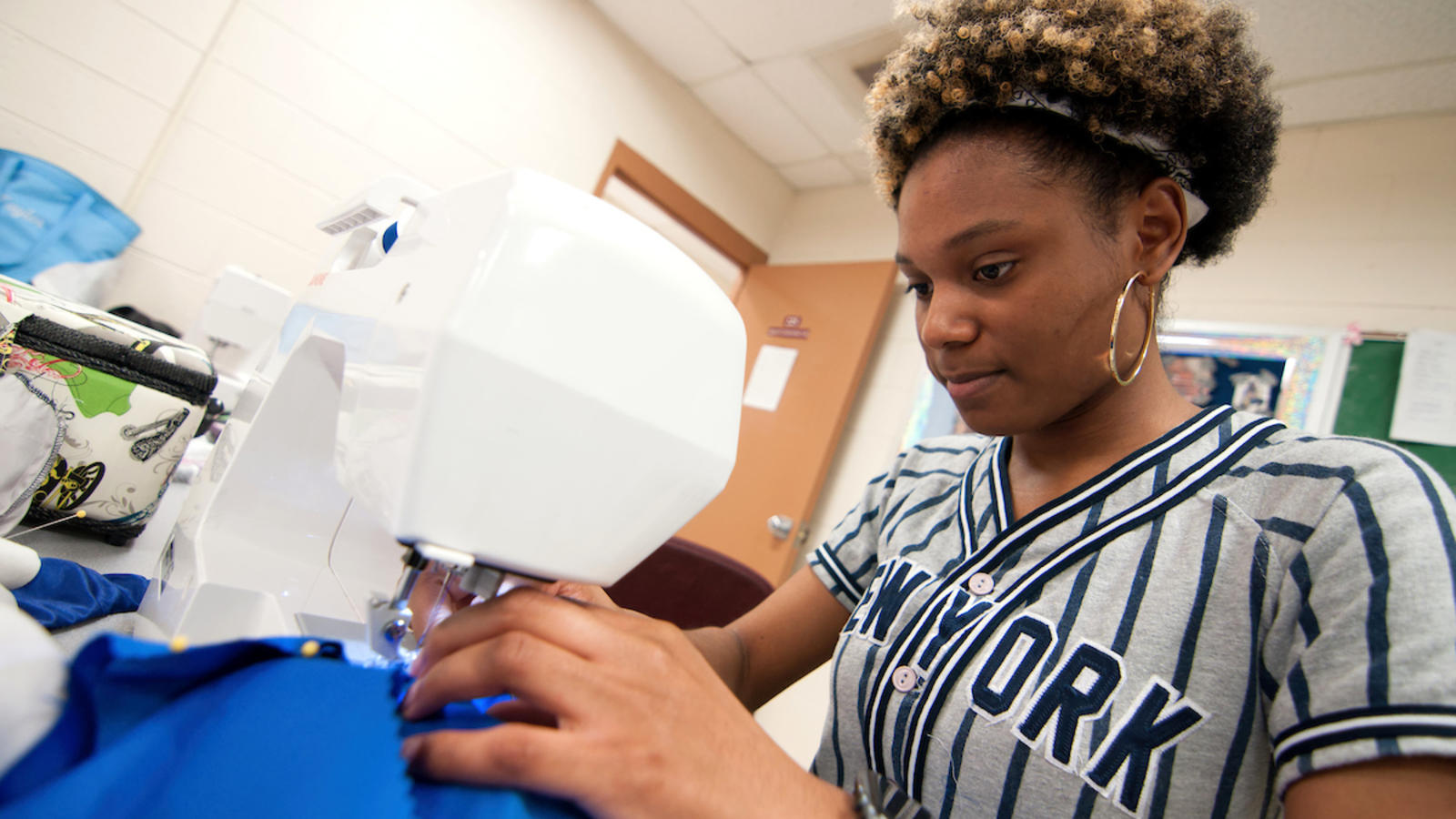 A fashion design student sewing a garment