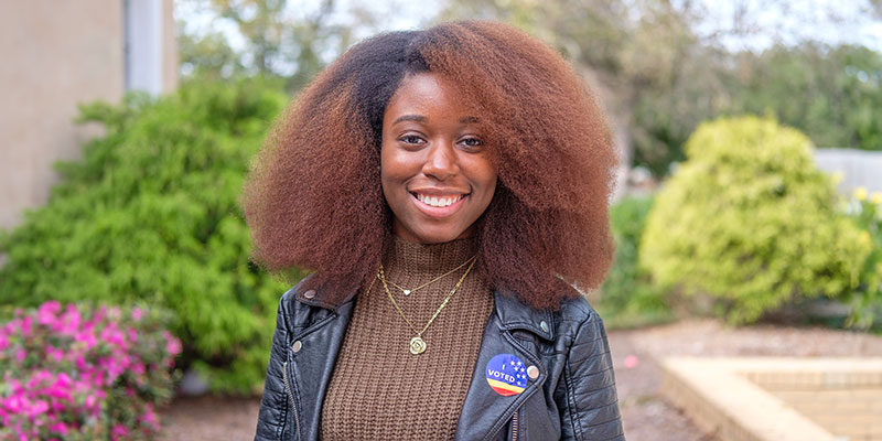 NCCU student wearing an "I VOTED" sticker, smiling