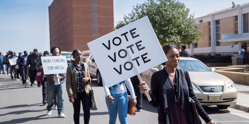 NCCU students marching with vote signs