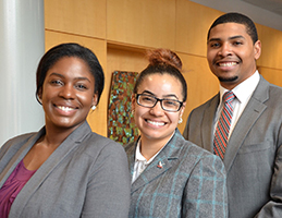 3 people in business attire smiling and posing for a picture