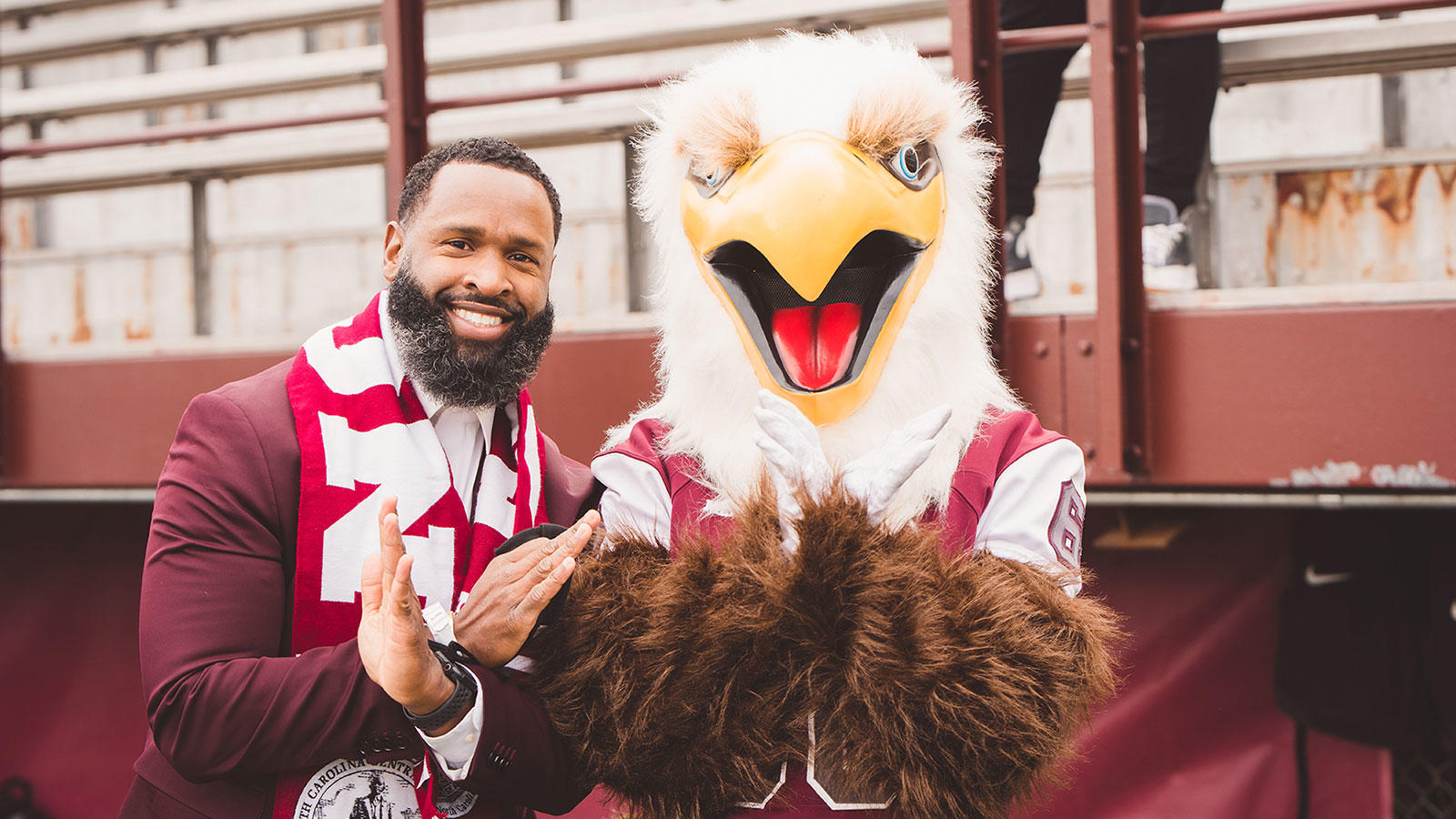 NCCU's mascot, Eddie the Eagle, and alum doing the eagle hand sign