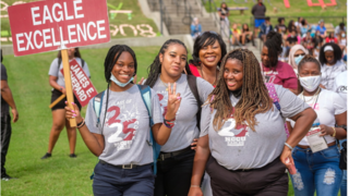 Students holding an Eagle Excellence sign.