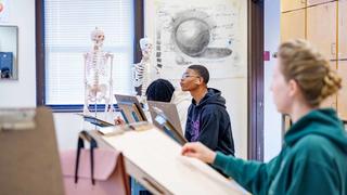 Students taking a studio art class looking at their easels