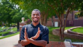 A MAC Student making the Eagle symbol