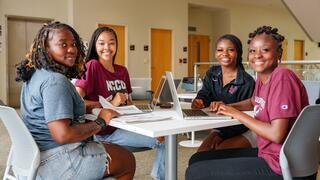 Four young women sitting at a table