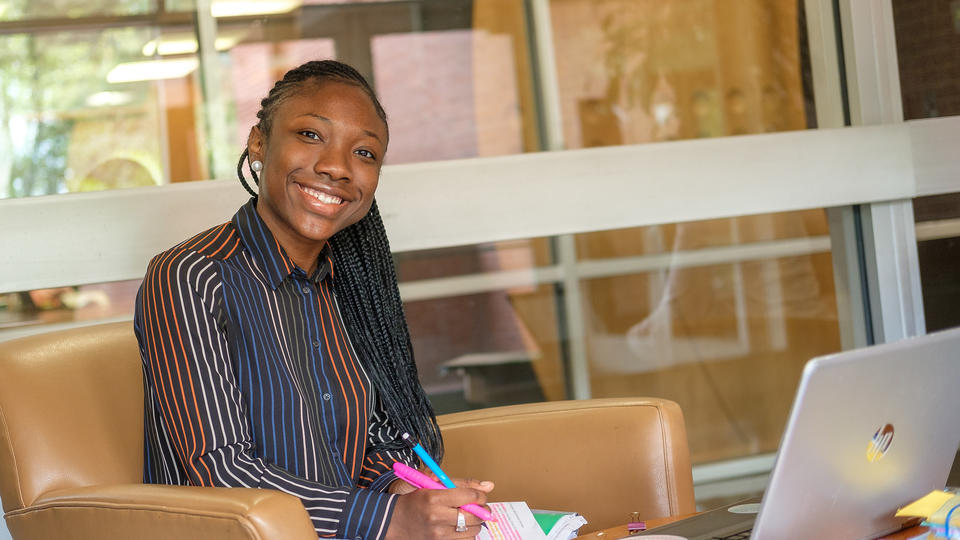 Student smiling while taking notes