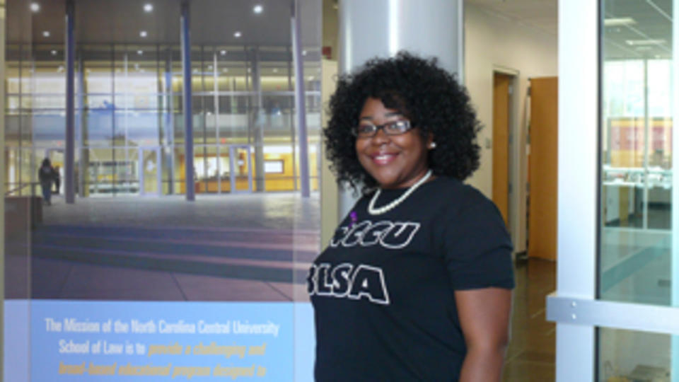 Image of a student standing in front of a building.