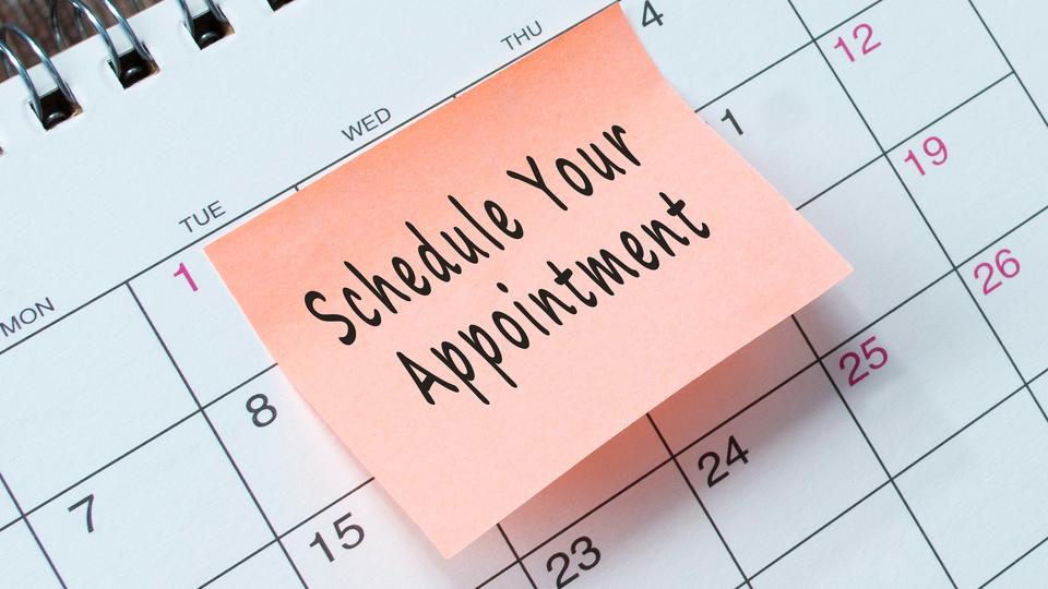 An image of a calendar with a sticky note on top that reads "Schedule your appointment"