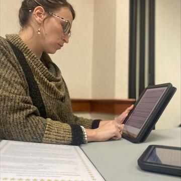 Woman sitting and working on tablet